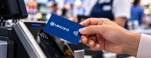 Cartão com chip aproximado da maquininha no caixa da loja